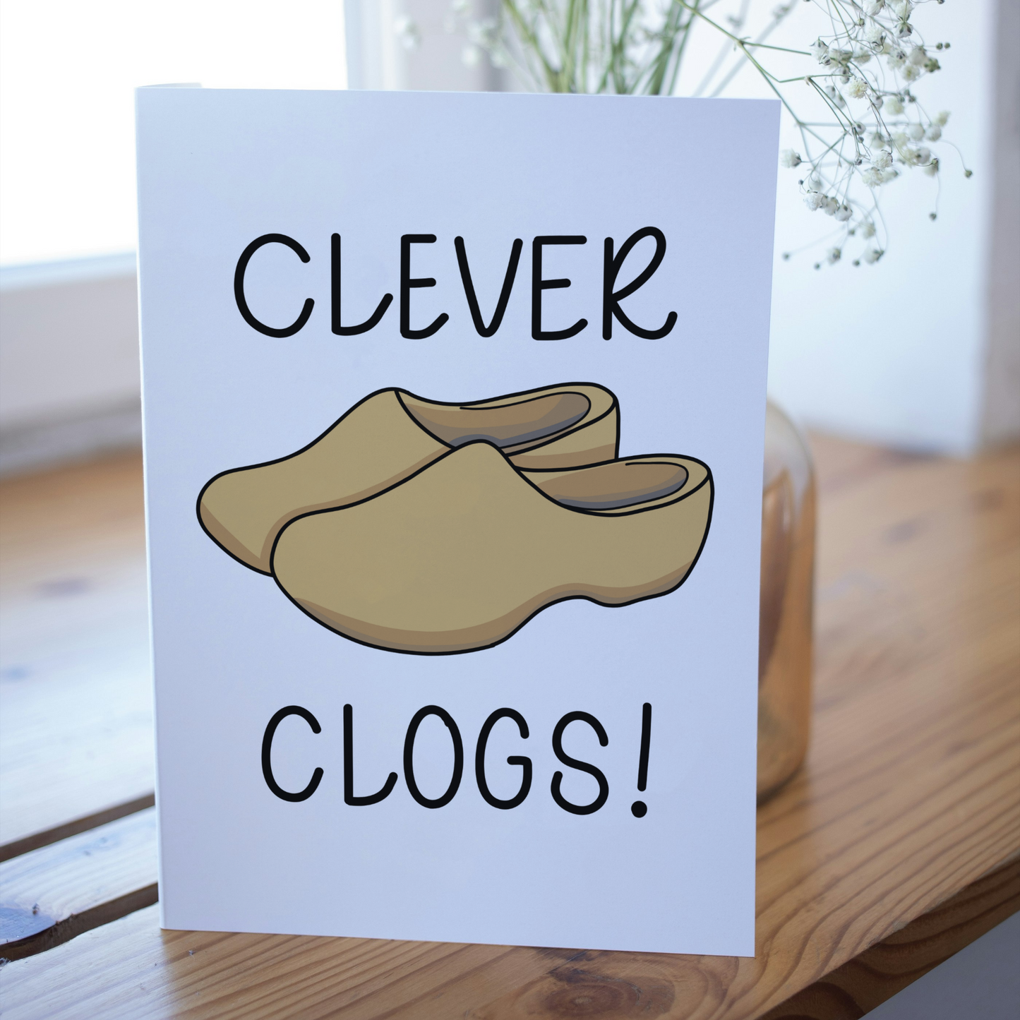 Card with 'Clever Clogs!' text and illustrations of wooden clogs on a light background.