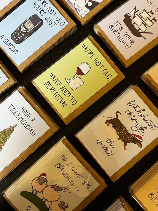 A selection of greeting card designs lying on a black background. 