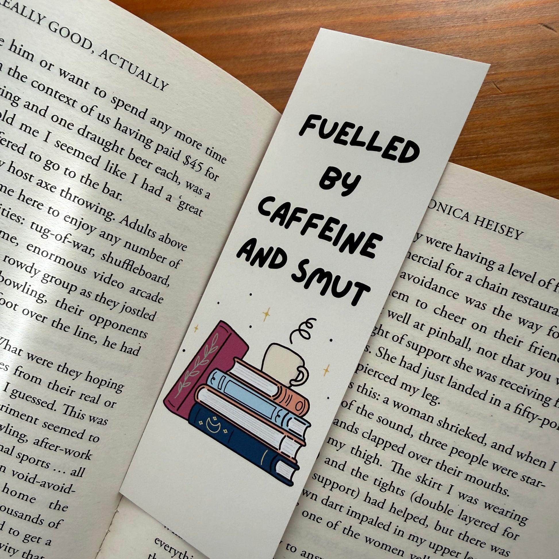 Bookmark with 'Fueled by Caffeine and Shut' text on an open book