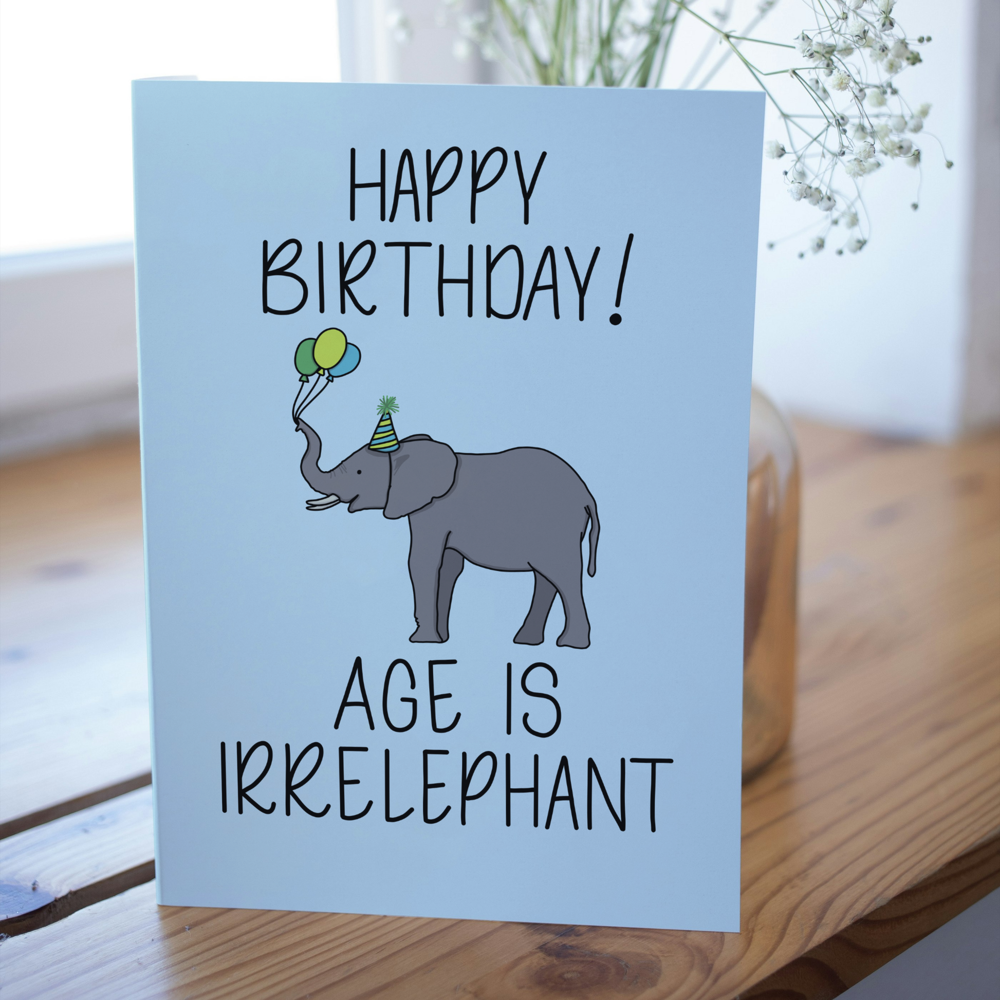 Birthday card with an elephant illustration and humorous text on a light blue background.