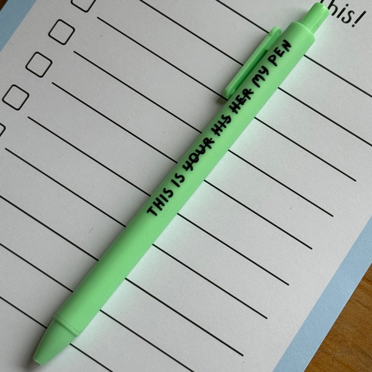 Green pen with text on a lined notepad