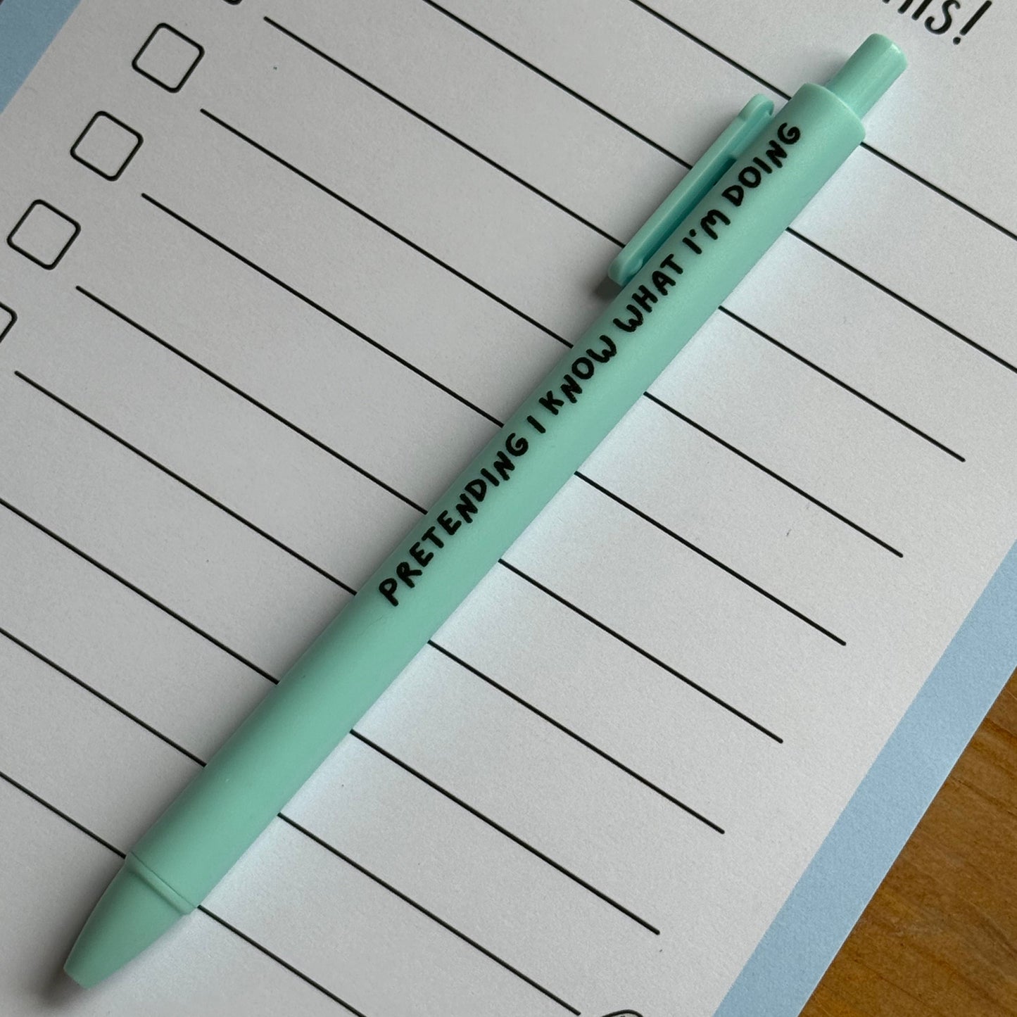 Light blue pen on a lined notepad with cartoon goose illustration