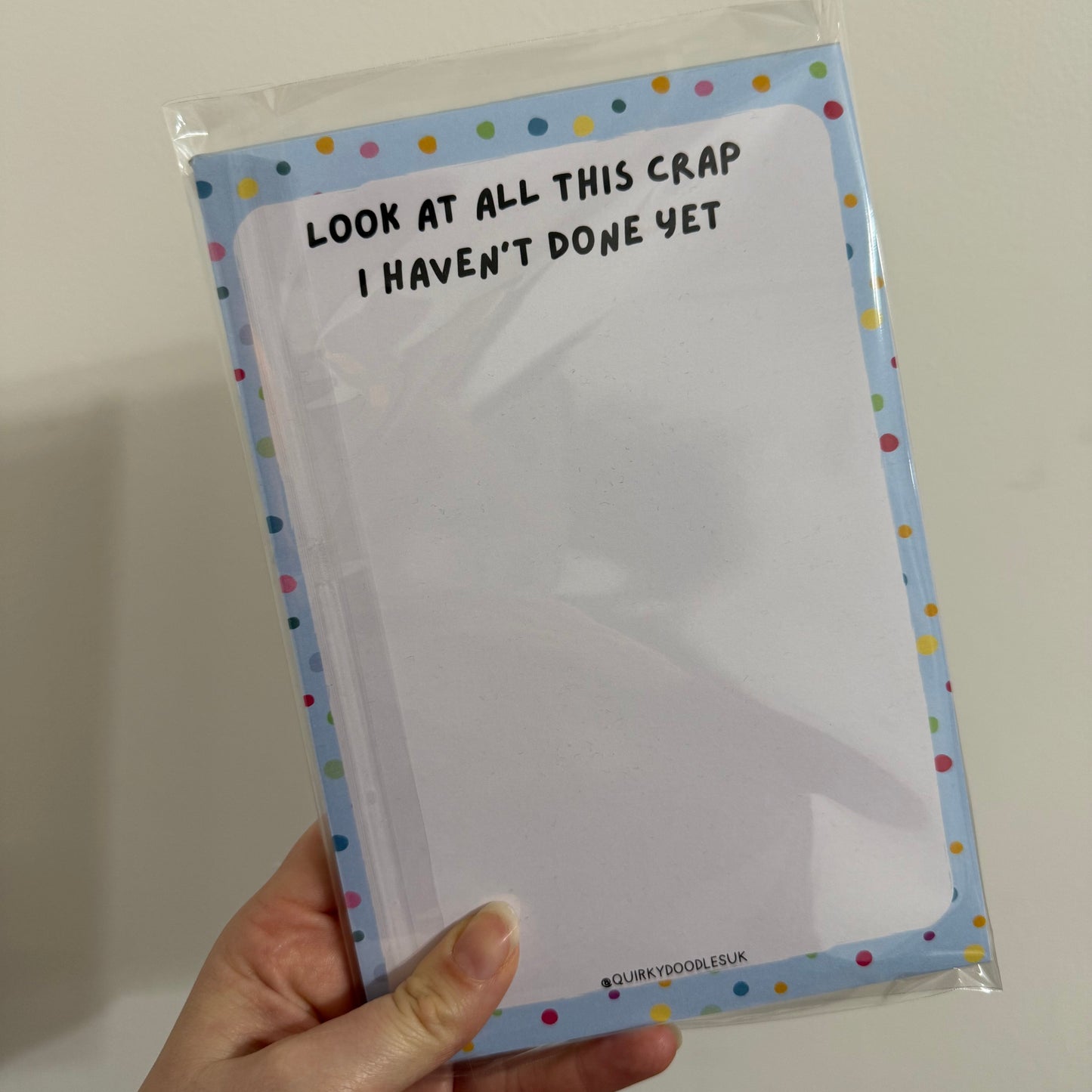 Hand holding a clear plastic sheet with text on a plain background