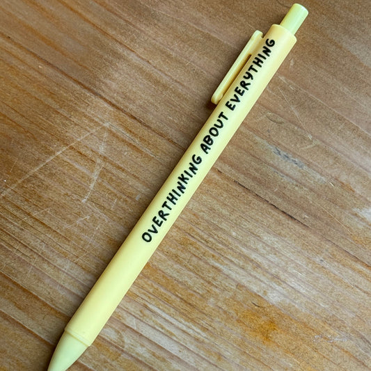 Yellow pen with text on a wooden surface