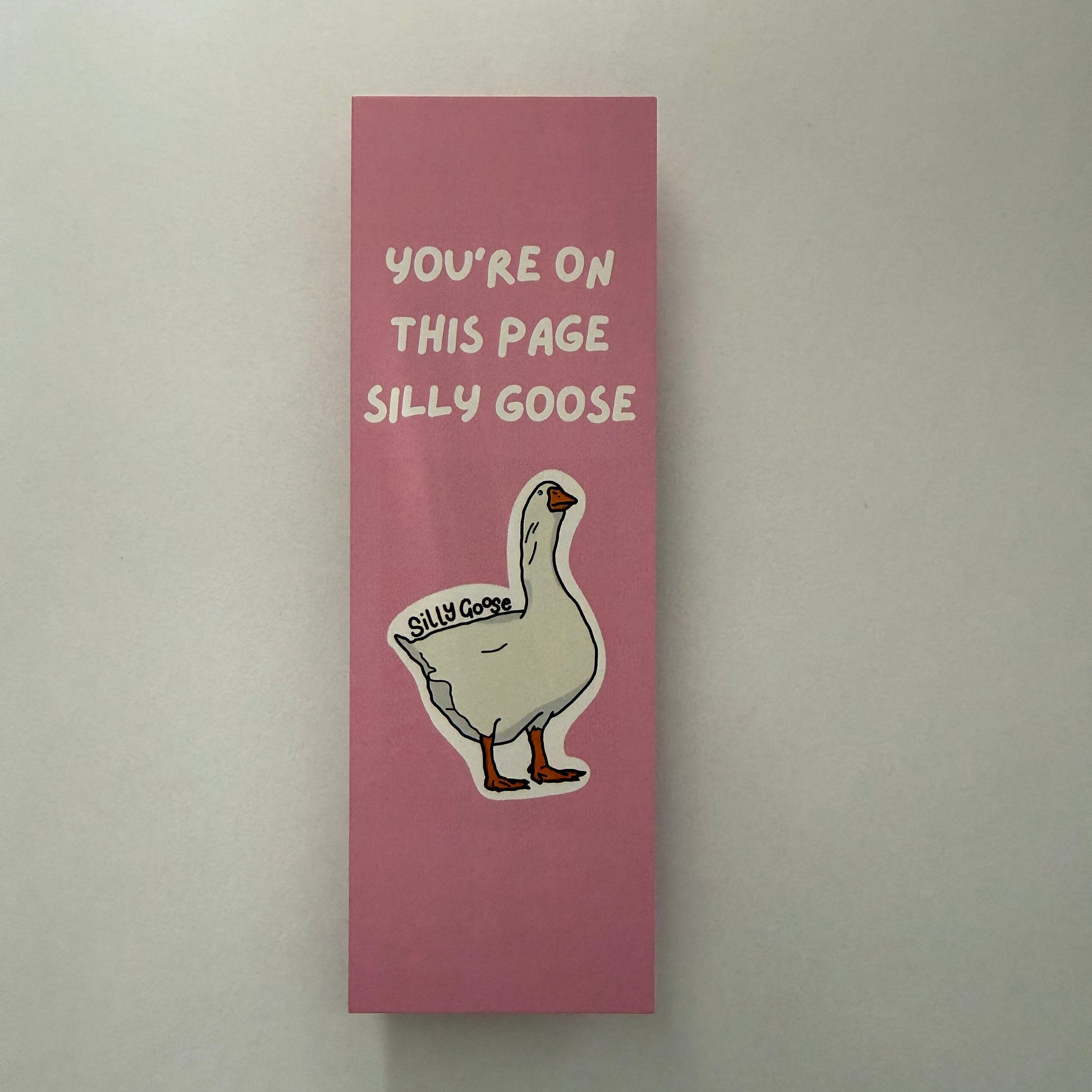 Pink bookmark with a cartoon goose and text on a white background