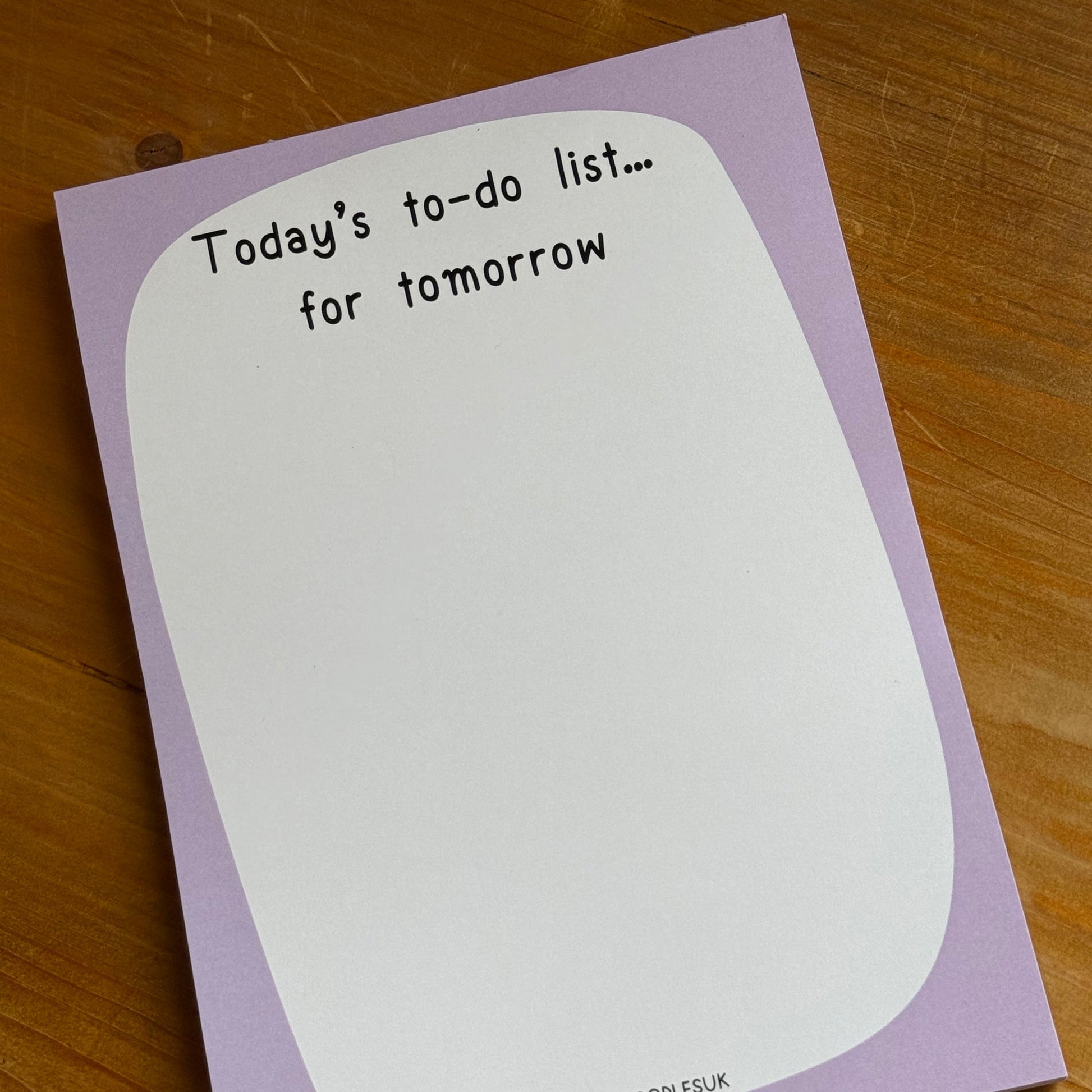 Notebook with a to-do list on a wooden surface